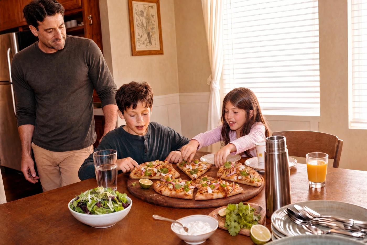 A family at dinner with BBQ chicken flatbreads